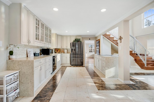 kitchen featuring white cabinets, ornamental molding, appliances with stainless steel finishes, and backsplash