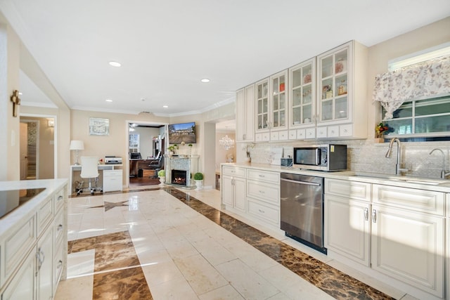 kitchen with sink, tasteful backsplash, ornamental molding, appliances with stainless steel finishes, and white cabinets