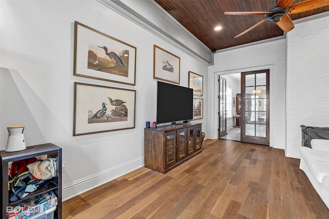 interior space with wood-type flooring, brick wall, wooden ceiling, and ceiling fan