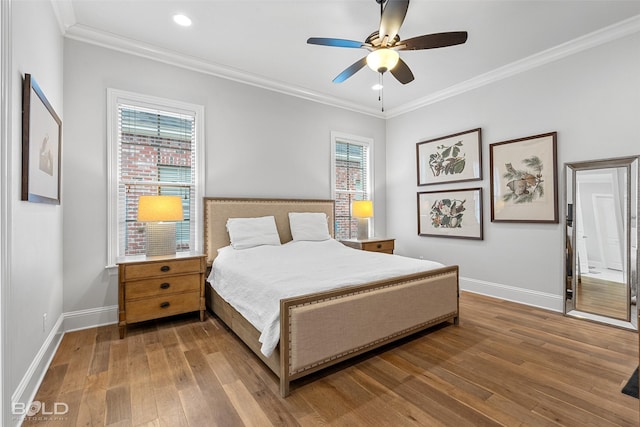 bedroom with hardwood / wood-style flooring, crown molding, and multiple windows