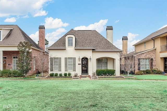 french country inspired facade featuring a front lawn