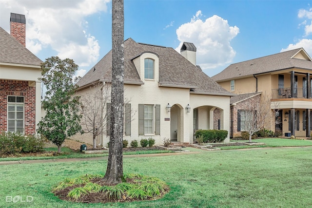 french country style house featuring a front yard