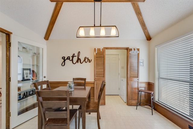 dining area with vaulted ceiling with beams, plenty of natural light, washer and dryer, and a textured ceiling