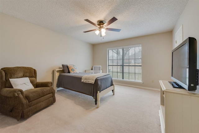 bedroom with light carpet, ceiling fan, and a textured ceiling