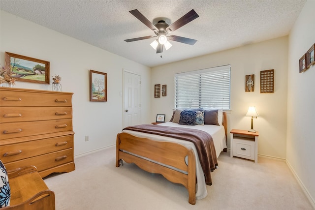 carpeted bedroom featuring ceiling fan and a textured ceiling