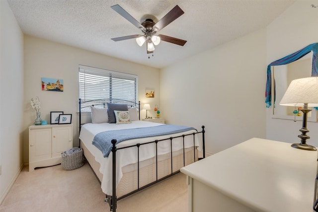 carpeted bedroom with ceiling fan and a textured ceiling