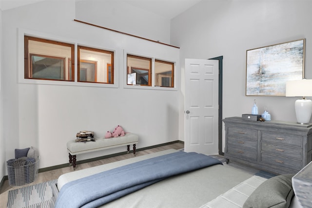 bedroom featuring lofted ceiling and light wood-type flooring