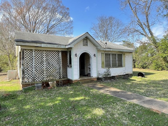 view of front of home featuring central AC and a front yard