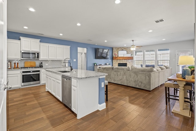 kitchen with stainless steel appliances, sink, a breakfast bar area, and white cabinets