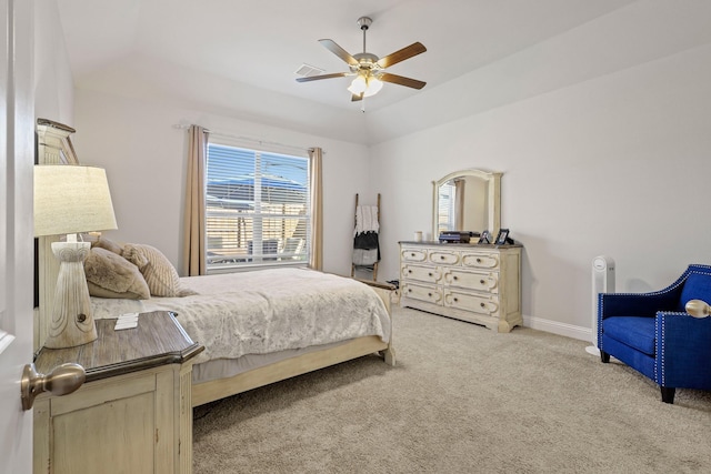 carpeted bedroom featuring ceiling fan and a tray ceiling