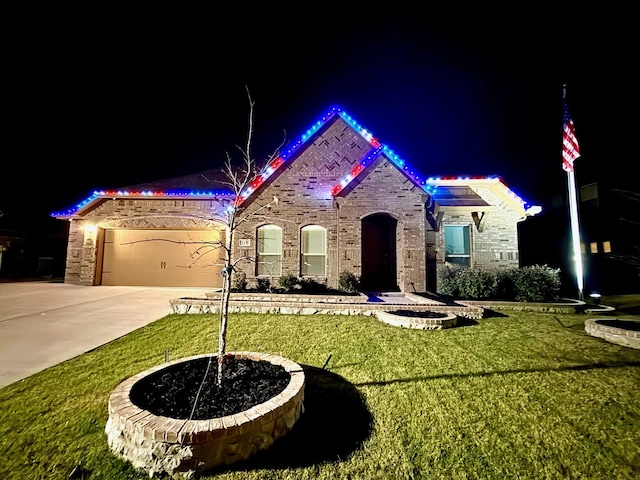 view of front of house featuring a garage and a lawn