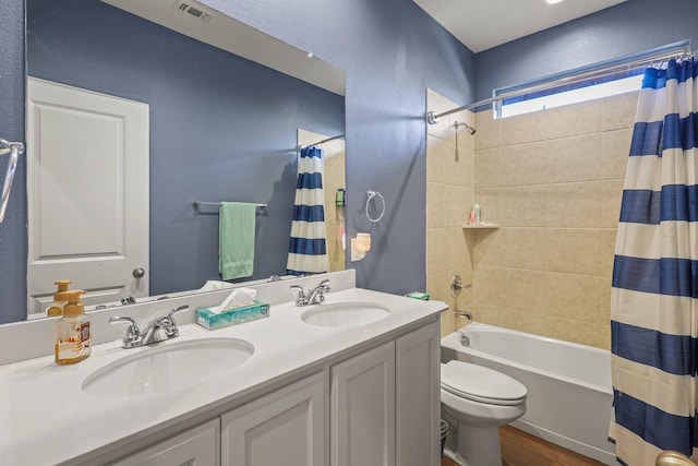 full bathroom with vanity, toilet, hardwood / wood-style floors, and shower / bath combo with shower curtain