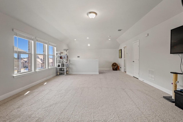 unfurnished living room featuring light colored carpet and vaulted ceiling