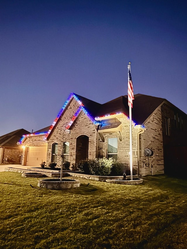 view of front of home featuring a garage and a lawn