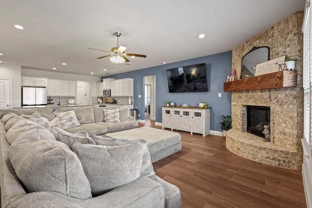 living room featuring a fireplace, dark hardwood / wood-style floors, and ceiling fan