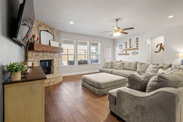 living room featuring a fireplace, dark hardwood / wood-style floors, and ceiling fan