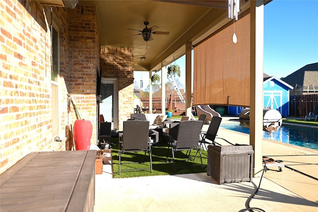 view of patio featuring a storage shed, outdoor lounge area, and ceiling fan