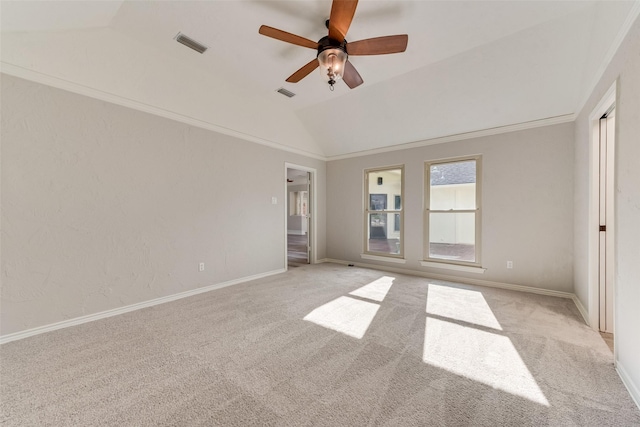 carpeted spare room featuring crown molding, ceiling fan, and vaulted ceiling