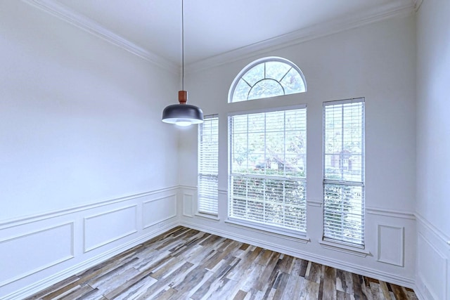 spare room with hardwood / wood-style floors and crown molding