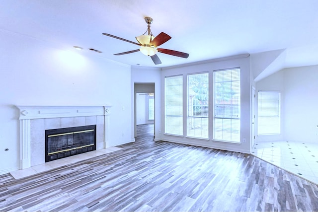 unfurnished living room featuring ceiling fan, a fireplace, and wood-type flooring