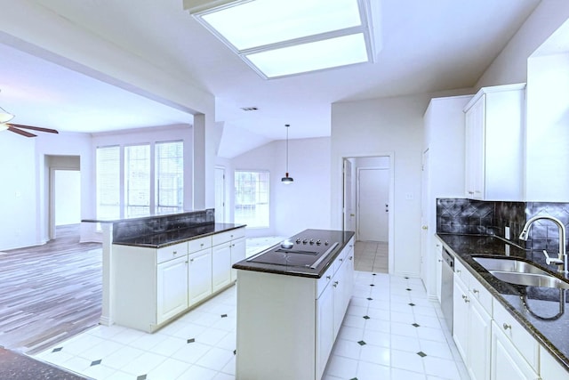 kitchen with sink, decorative light fixtures, white cabinets, and a kitchen island