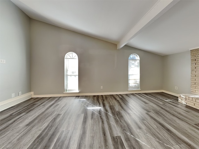 unfurnished living room featuring hardwood / wood-style floors and vaulted ceiling with beams