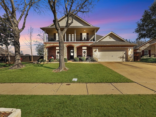 view of front of property with a garage, a balcony, and a lawn