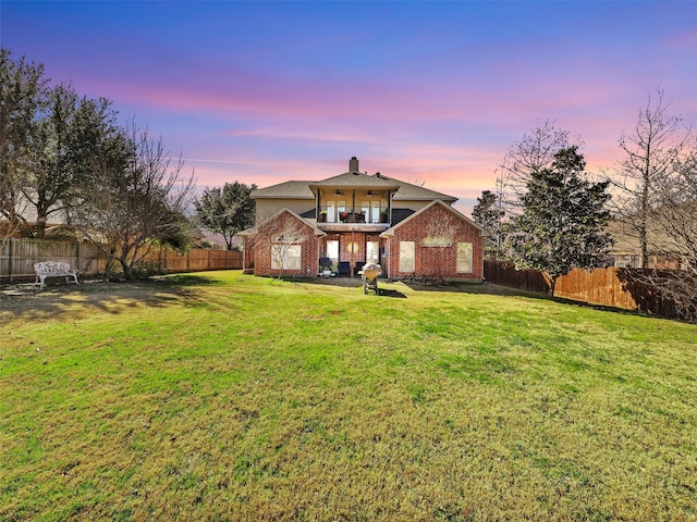 front of property with a lawn and a balcony