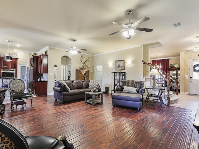 living room featuring ceiling fan with notable chandelier, ornamental molding, and dark hardwood / wood-style floors