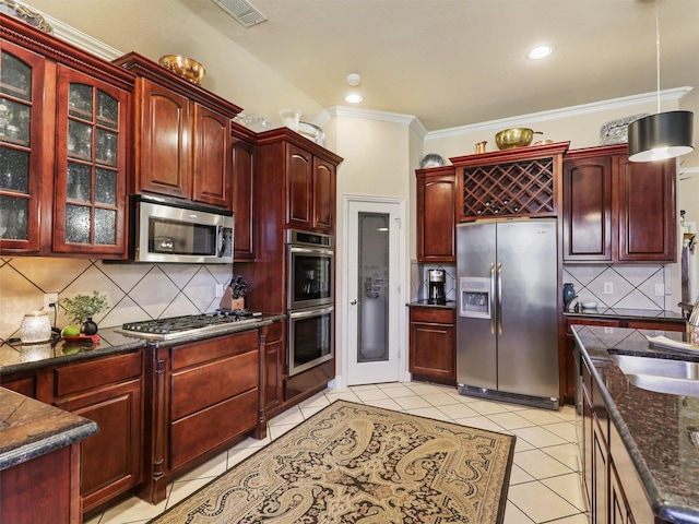 kitchen featuring light tile patterned flooring, sink, crown molding, appliances with stainless steel finishes, and decorative backsplash