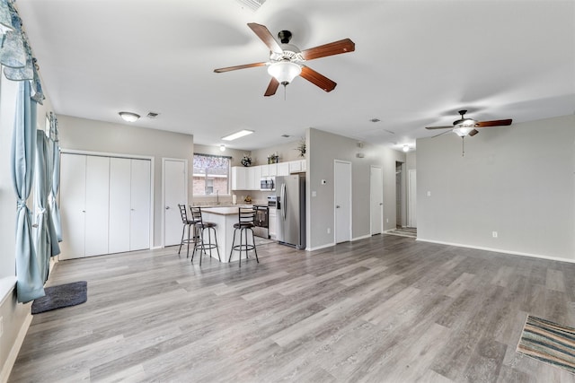 unfurnished living room with ceiling fan and light hardwood / wood-style floors