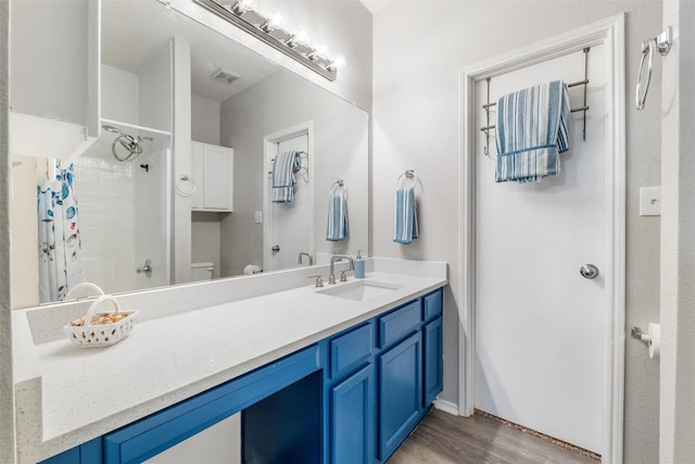 bathroom with vanity, hardwood / wood-style floors, toilet, and walk in shower