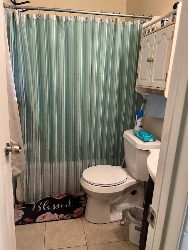 bathroom with toilet, curtained shower, and tile patterned flooring