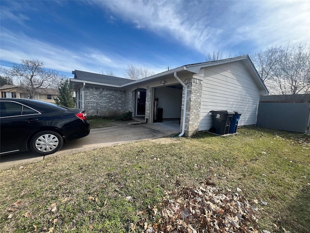 view of side of home featuring a garage and a lawn