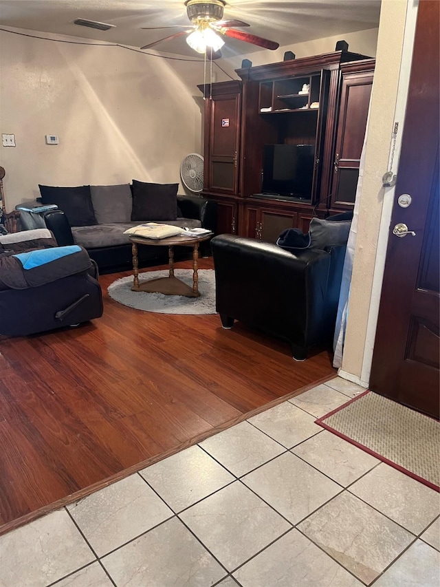 tiled living room with ceiling fan