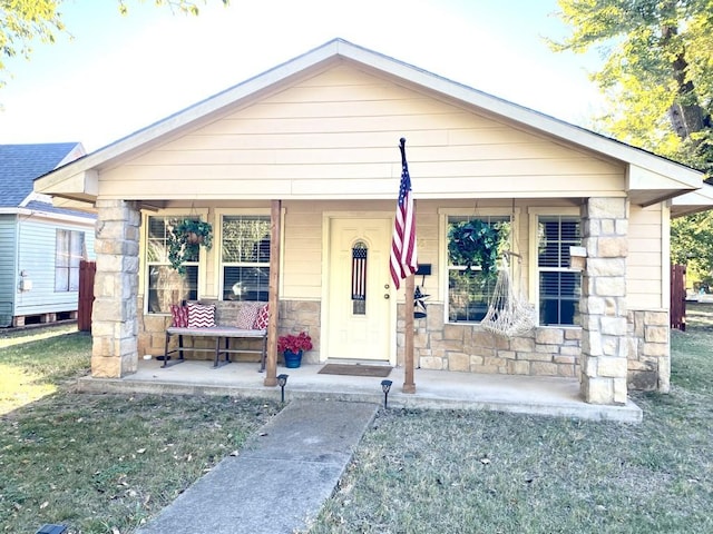 bungalow-style home with covered porch and a front lawn