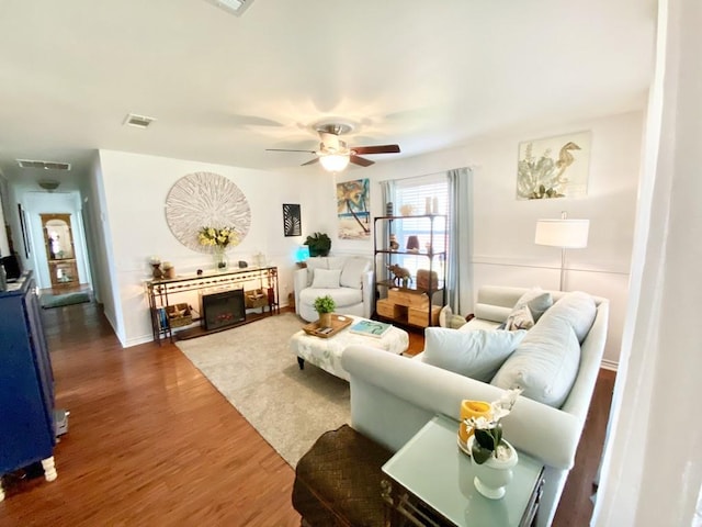 living room with ceiling fan and dark hardwood / wood-style flooring