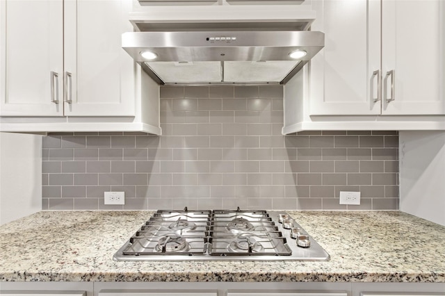 kitchen with ventilation hood, white cabinets, and stainless steel gas stovetop