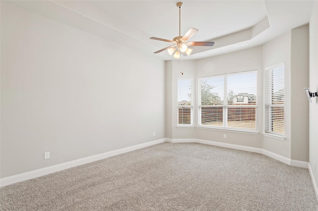 carpeted empty room featuring ceiling fan and a tray ceiling