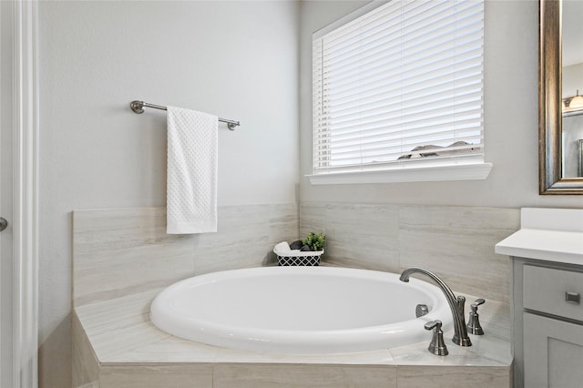 bathroom with vanity and tiled bath