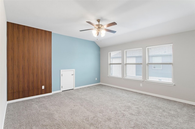 carpeted empty room featuring vaulted ceiling and ceiling fan