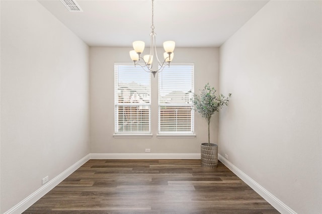 unfurnished room featuring dark hardwood / wood-style flooring and a chandelier