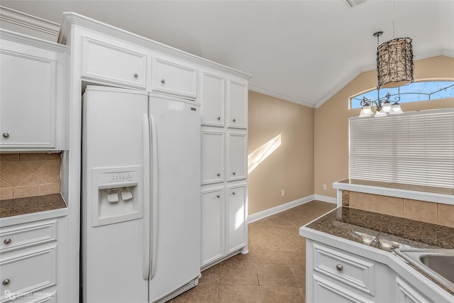 kitchen with white refrigerator with ice dispenser, pendant lighting, and white cabinets