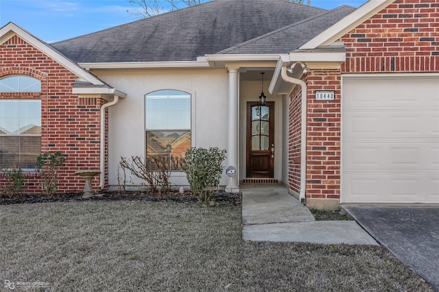 view of exterior entry featuring a garage and a yard