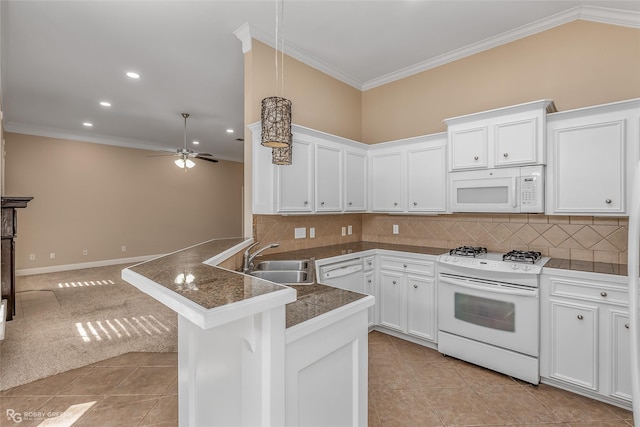 kitchen with sink, white appliances, backsplash, ornamental molding, and kitchen peninsula