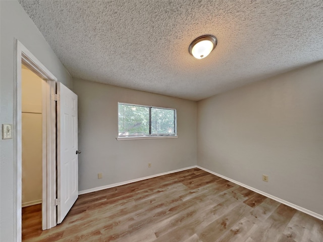 empty room featuring light hardwood / wood-style floors and a textured ceiling