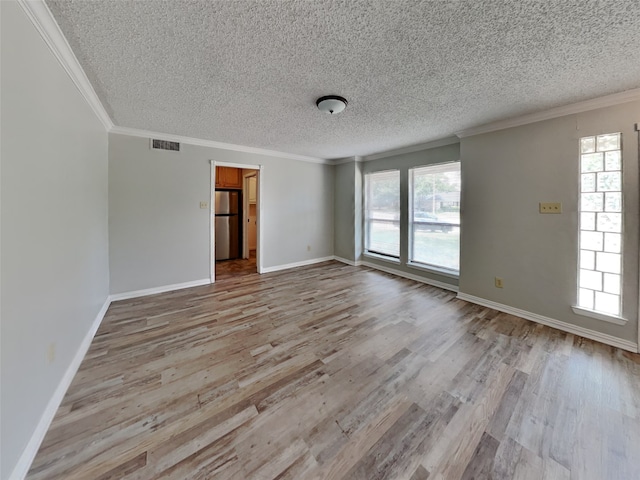 unfurnished room featuring ornamental molding, a textured ceiling, and light hardwood / wood-style flooring