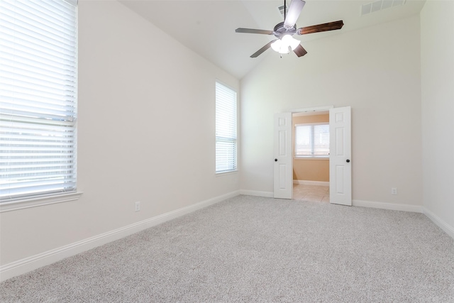 carpeted spare room featuring vaulted ceiling and ceiling fan