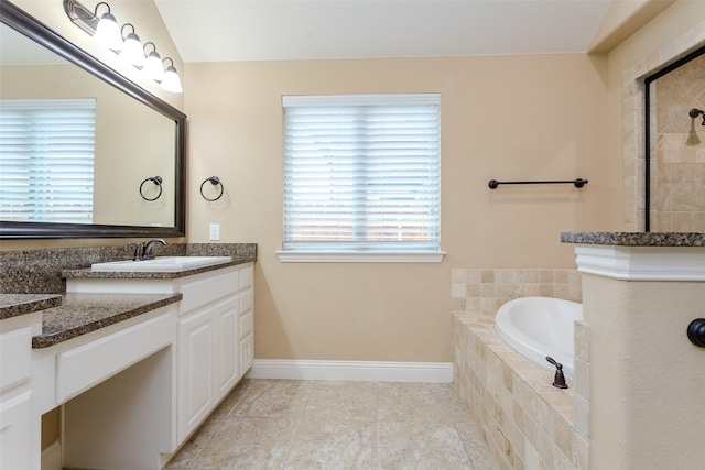 bathroom featuring vanity, tile patterned flooring, and tiled bath