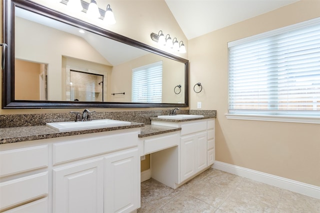 bathroom featuring lofted ceiling, vanity, tile patterned flooring, and a shower